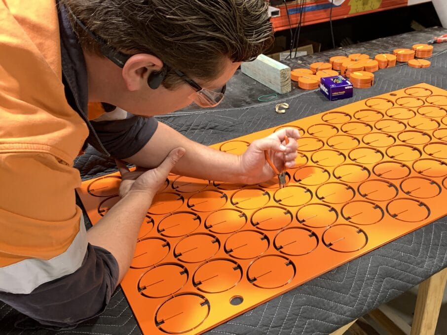 Hand cutting discs for Everchange by Benjamin Shine at Denman Prospect in Canberra, supported by Tilt Industrial Design, Public Art Specialists.